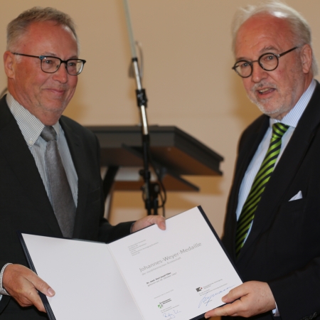 Rudolf Henke (re.) überreicht Dr. Karl-Josef Eßer die Auszeichnung.